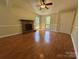 Open living room features brick fireplace, hardwood floors, and a seamless transition to the front entryway at 8000 Tiburon Cir, Charlotte, NC 28215