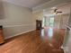 Sunlit living room with hardwood floors, brick fireplace, and open access to the front door and kitchen at 8000 Tiburon Cir, Charlotte, NC 28215