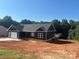 Newly constructed one-story home featuring a black exterior, garage, and a large front yard at 85 Cornerstone Dr, Taylorsville, NC 28681