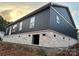 New construction home with dark blue exterior and white brick base; long view of the side and back of the house at 85 Cornerstone Dr, Taylorsville, NC 28681