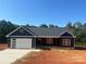 Charming home featuring a modern garage, dark siding, and a welcoming front porch at 85 Cornerstone Dr, Taylorsville, NC 28681