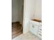 Hallway with white cabinets with gold hardware, white walls, and a mix of wood and marble tile flooring at 85 Cornerstone Dr, Taylorsville, NC 28681