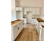 New kitchen features white cabinets, gold hardware, a large island, and sleek wood flooring for a modern look at 85 Cornerstone Dr, Taylorsville, NC 28681