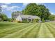 Quaint one-story home featuring manicured lawn and landscaping, with trees in the background at 878 Cold Springs Rd, Concord, NC 28025