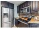 Modern kitchen featuring stainless steel appliances, granite countertops, and custom dark wood cabinetry at 878 Cold Springs Rd, Concord, NC 28025