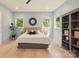 Bright bedroom featuring light wood floors, a modern mirror, and a large bed at 9305 Valley Rd, Charlotte, NC 28270