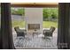 Relaxing outdoor patio with a fireplace, comfortable seating, and a view of the well-maintained backyard at 9305 Valley Rd, Charlotte, NC 28270