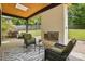Covered patio boasts a fireplace, comfortable wicker chairs, and views of the landscaped backyard and lush greenery at 9305 Valley Rd, Charlotte, NC 28270