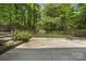 Concrete patio in a fenced backyard with mature trees and shrubs at 9707 Enid Ln, Matthews, NC 28105