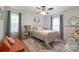 Cozy bedroom featuring an ornate white bed frame, ceiling fan, and eye-catching area rug at 9707 Enid Ln, Matthews, NC 28105