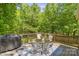 Outdoor wooden deck showcasing a grill, seating, and views of the surrounding foliage at 9707 Enid Ln, Matthews, NC 28105