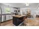 Spacious kitchen with a central island, white cabinets, granite countertops and stainless appliances at 9707 Enid Ln, Matthews, NC 28105