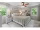 Cozy bedroom featuring a bed with decorative pillows, side tables, and a ceiling fan at 9707 Enid Ln, Matthews, NC 28105