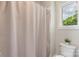 A simple bathroom showcasing a shower with a curtain and a modern toilet with green plants at 1004 Berwick Ct, Waxhaw, NC 28173