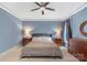 Cozy primary bedroom with a ceiling fan, blue walls, and two side tables at 1004 Berwick Ct, Waxhaw, NC 28173