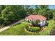 Stunning home with a red roof, lush landscaping, and a circular driveway at 1004 Berwick Ct, Waxhaw, NC 28173