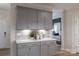 Bright kitchen featuring gray cabinets, quartz counters and decorative backsplash at 12017 Grinstead Ln # 301, Charlotte, NC 28278
