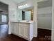 Bathroom featuring a double vanity with modern fixtures, quartz counters, and an adjacent walk-in closet at 12713 Frank Wiley Ln, Charlotte, NC 28278