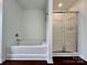 Clean bathroom featuring a soaking tub with tile surround and a separate shower with sliding glass doors at 12713 Frank Wiley Ln, Charlotte, NC 28278