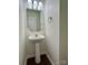 Half bath with pedestal sink and octagon mirror at 12713 Frank Wiley Ln, Charlotte, NC 28278