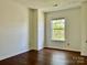 A sunlit bedroom with a neutral color palette and large window that provides a view at 12713 Frank Wiley Ln, Charlotte, NC 28278