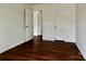 A light-filled bedroom featuring multiple doors and elegant dark hardwood flooring at 12713 Frank Wiley Ln, Charlotte, NC 28278