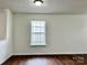 Cozy room featuring wood-look floors, neutral walls, white trim, and a window with bright natural light at 12713 Frank Wiley Ln, Charlotte, NC 28278