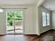 Dining area with wood-look flooring, sliding glass doors to backyard deck, and lots of natural light at 12713 Frank Wiley Ln, Charlotte, NC 28278