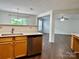 Open kitchen view showcases wood cabinets, a dishwasher, and modern sink at 12713 Frank Wiley Ln, Charlotte, NC 28278