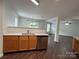 Bright kitchen features stainless steel appliances, wood cabinets, and hardwood floors at 12713 Frank Wiley Ln, Charlotte, NC 28278