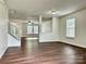 Open-concept living space with staircase, neutral paint, wood-look flooring, and natural light from multiple windows at 12713 Frank Wiley Ln, Charlotte, NC 28278