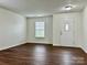 Bright living room with wood-look flooring, a window for natural light, and a white front door at 12713 Frank Wiley Ln, Charlotte, NC 28278