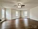 Spacious main bedroom with ceiling fan, hardwood floors and multiple windows at 12713 Frank Wiley Ln, Charlotte, NC 28278