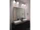 Modern bathroom featuring double sinks with black fixtures and a large mirror with decorative lighting at 1354 Briar Creek Rd, Charlotte, NC 28205