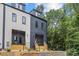 A modern townhome exterior with stylish color scheme, wooden stairs, and adjacent landscaping at 1354 Briar Creek Rd, Charlotte, NC 28205