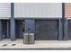 Garage exterior with dark gray door and siding, side door entrance, and AC unit at 1354 Briar Creek Rd, Charlotte, NC 28205