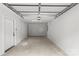 A well-lit garage with a clean, unfinished concrete floor and a white door at 1354 Briar Creek Rd, Charlotte, NC 28205