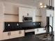 Close up of kitchen with sleek white cabinets, black countertops, backsplash and floating shelves at 1354 Briar Creek Rd, Charlotte, NC 28205