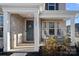 Welcoming front porch with decorative columns, a stylish front door with a wreath, and hanging swing chairs at 14004 Fiery Mist Way, Huntersville, NC 28078