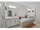 Bright main bathroom with double vanity, a soaking tub, and large mirrors for a spa-like experience at 14004 Fiery Mist Way, Huntersville, NC 28078