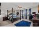 Spacious main bedroom featuring a decorative four-poster bed, tray ceilings, and bright window lighting at 14004 Fiery Mist Way, Huntersville, NC 28078