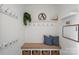 Well-organized mudroom with a bench, storage cubbies, hooks, and a decorative 