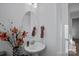 Stylish powder room with a pedestal sink, decorative mirror, and accent flowers for a touch of elegance at 14004 Fiery Mist Way, Huntersville, NC 28078