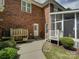 Backyard featuring a well-maintained lawn, brick house exterior, landscaping, and an access to the screened-in porch at 15824 Feeny Ct, Charlotte, NC 28278