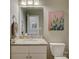 Bathroom with a granite countertop, white cabinets, decorative art, and modern fixtures at 15824 Feeny Ct, Charlotte, NC 28278