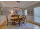 Elegant dining room with a classic wooden table, six chairs, and a unique chandelier lighting fixture at 15824 Feeny Ct, Charlotte, NC 28278