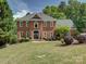 Beautiful red brick home featuring a manicured front lawn and classic architectural details at 15824 Feeny Ct, Charlotte, NC 28278