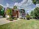 Expansive backyard with mature trees highlights the home's beautiful brick exterior, screened porch, and outdoor living spaces at 15824 Feeny Ct, Charlotte, NC 28278