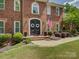 Elegant brick home featuring a covered front entry, symmetrical landscaping, and an American flag at 15824 Feeny Ct, Charlotte, NC 28278