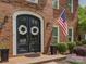 Detailed view of the home's arched double front doors with wreath decor, complemented by classic brickwork at 15824 Feeny Ct, Charlotte, NC 28278